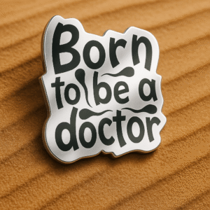 Glossy black and white brooch featuring the quote "Born to be a doctor" in bold, playful lettering.