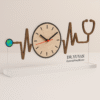 Acrylic table clock with heartbeat waveform and stethoscope design, wood-inlay finish, and doctor’s name