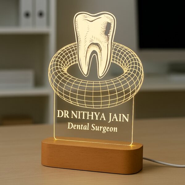 A custom LED night lamp featuring a 3D tooth design with the name “Dr. Nithya Jain, Dental Surgeon” engraved on illuminated acrylic with a wooden base.