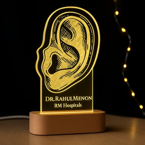 Custom LED night light with an anatomical ear illustration, engraved with “Dr. Rahul Meno – RM Hospitals,” glowing on a wooden base.