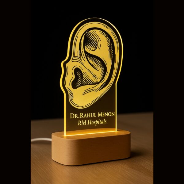Custom LED night light with an anatomical ear illustration, engraved with “Dr. Rahul Meno – RM Hospitals,” glowing on a wooden base.
