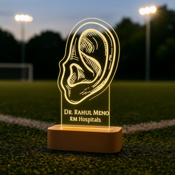 Custom LED night light with an anatomical ear illustration, engraved with “Dr. Rahul Meno – RM Hospitals,” glowing on a wooden base.