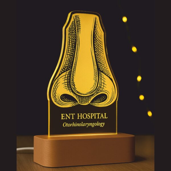 Custom LED night lamp with an engraved anatomical nose illustration and the label “ENT Hospital – Otorrhinolaryngology,” glowing warmly on a wooden base during dusk.