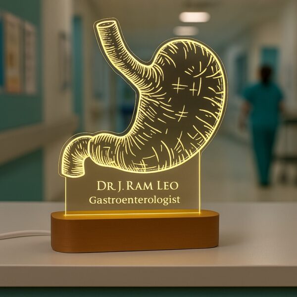 Customized LED night lamp with a glowing anatomical stomach design, engraved with “Dr. J. Ram Leo – Gastroenterologist,” placed on a wooden base in a hospital hallway.