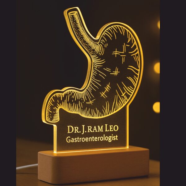 Customized LED night lamp with a glowing anatomical stomach design, engraved with “Dr. J. Ram Leo – Gastroenterologist,” placed on a wooden base in a hospital hallway.