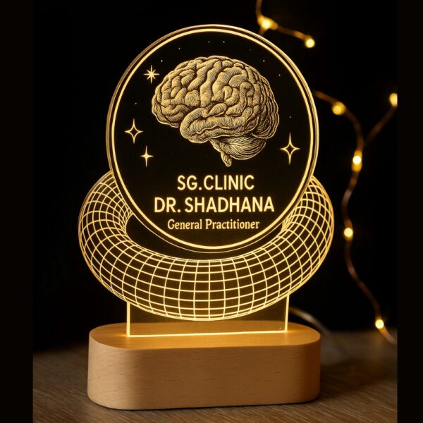 Custom LED night lamp with an engraved brain design and the text “SG. Clinic – Dr. Shadhana, General Practitioner” glowing on a wooden base, placed on a doctor’s desk.