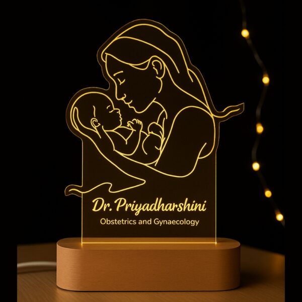 Personalized LED night lamp featuring a glowing line art illustration of a mother holding her newborn, engraved with “Dr. Priyadharshini – Obstetrics and Gynaecology,” displayed on a wooden base.