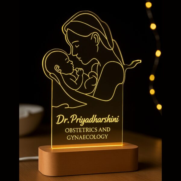 Personalized LED night lamp featuring a glowing line art illustration of a mother holding her newborn, engraved with “Dr. Priyadharshini – Obstetrics and Gynaecology,” displayed on a wooden base.