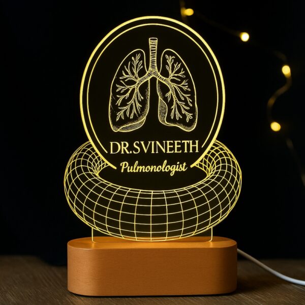 Personalized LED night lamp featuring an anatomical lung illustration, floral wreath, and the name “Dr. S. Vineeth – Pulmonologist,” glowing on a wooden base in a clinic setting.