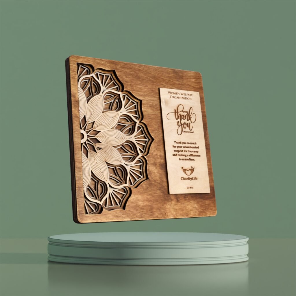 Intricately carved wooden plaque with mandala design and engraved appreciation message for medical camp contribution.