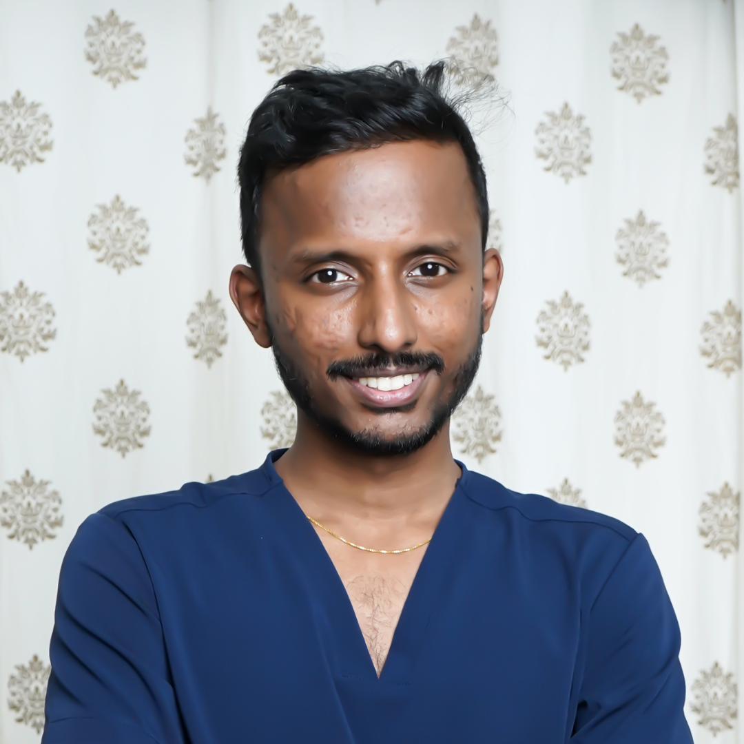 Dr. Arul Vel, Pediatrician and Co-Founder of Brittle, smiling in a blue scrub top.