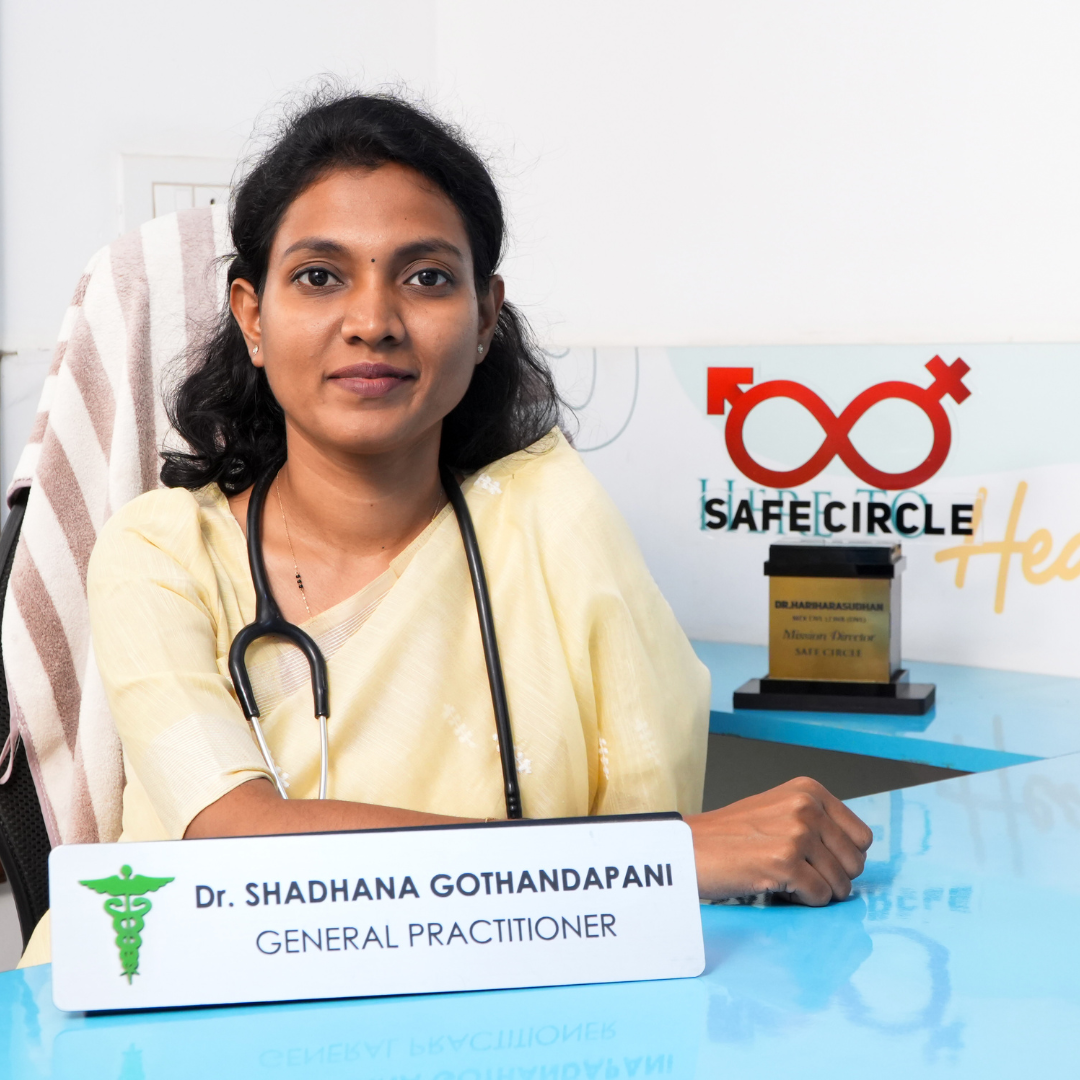 Dr. Shadhana Gothandapani, General Practitioner, seated with stethoscope at clinic desk beside a Safe Circle award.